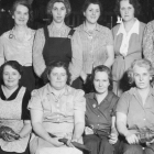 A group of women workers cradling their tools.